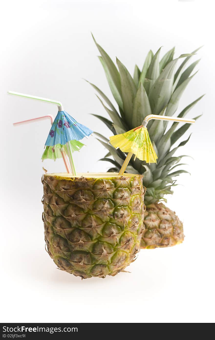 Pineapple with three straws and umbrellas isolated