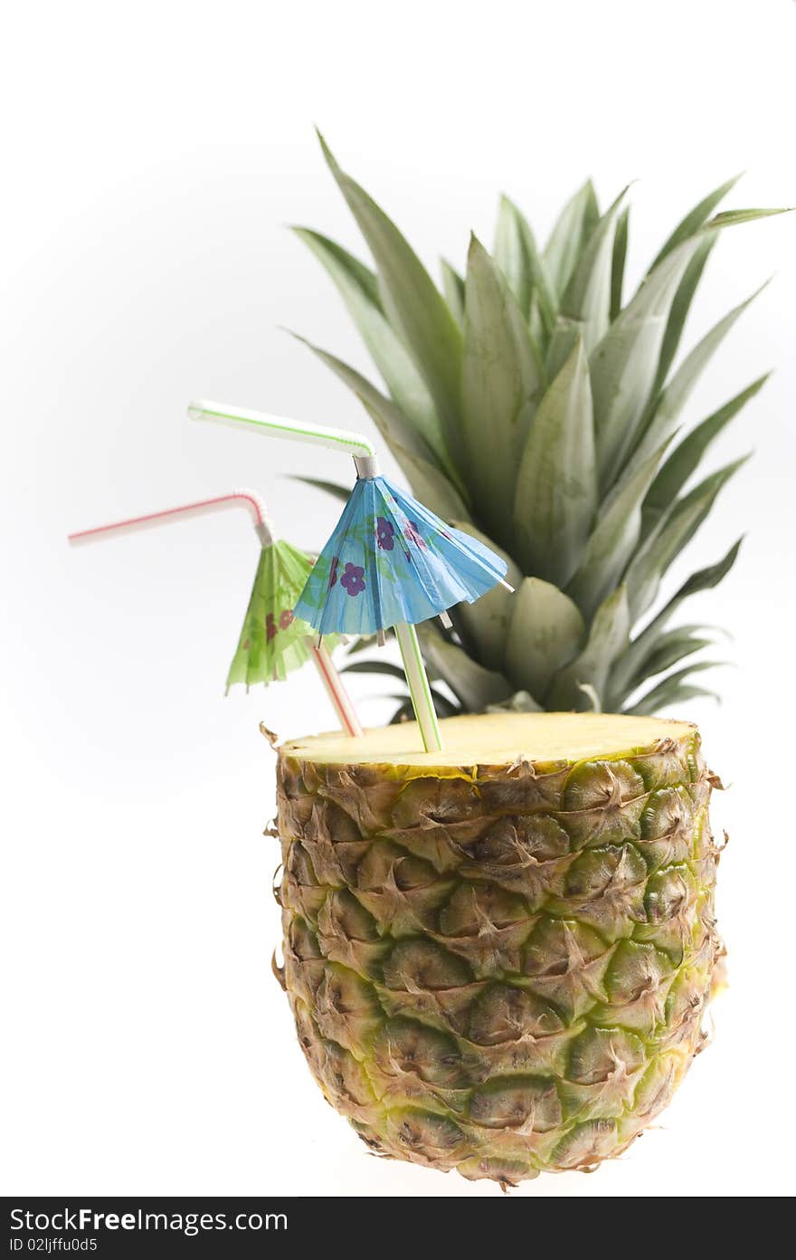 Pineapple with two straws and umbrellas isolated