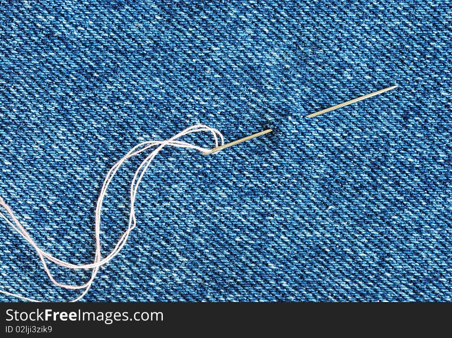 The needle with a thread through the jean