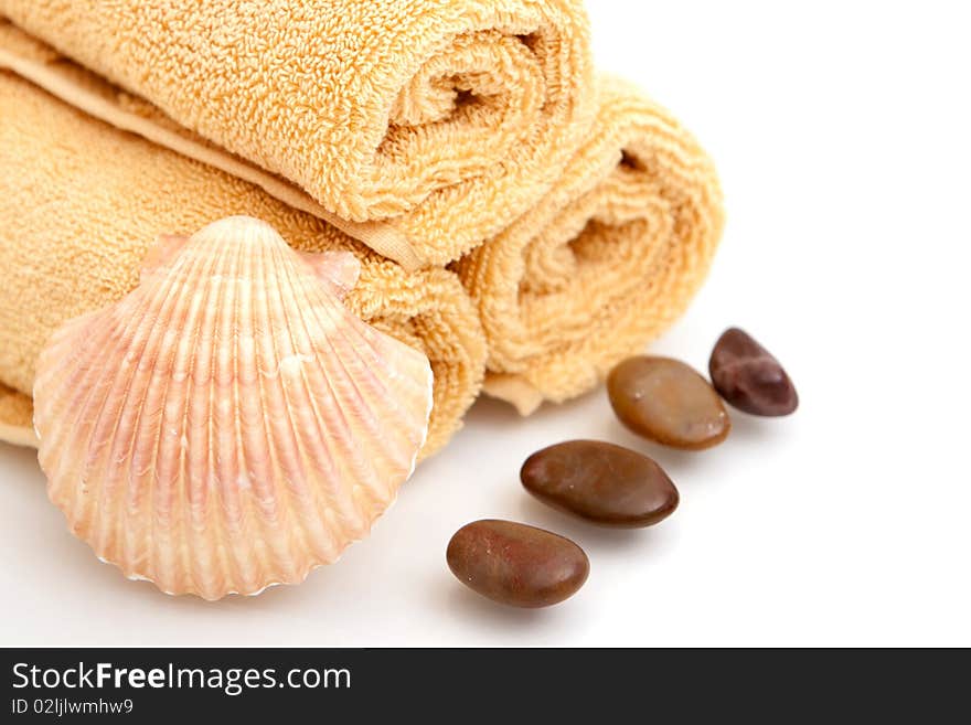 Spa decor with towels, pebbles and seashell