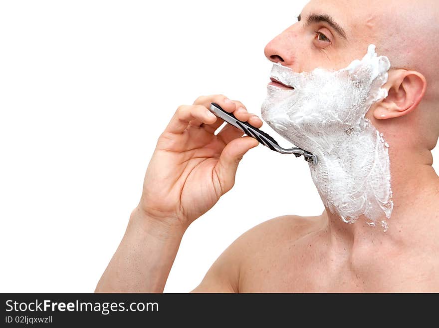 Young man shaving with a razorblade