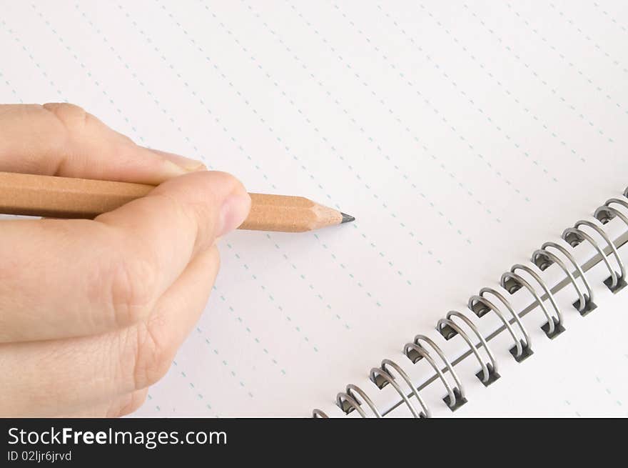 Pencil in hand, wrote in a notebook on a white background