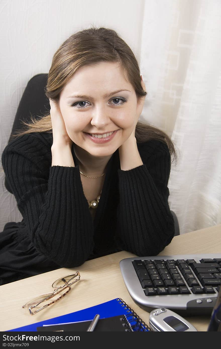 Secretary or Businesswoman a black dress sits at a desktop. Secretary or Businesswoman a black dress sits at a desktop.