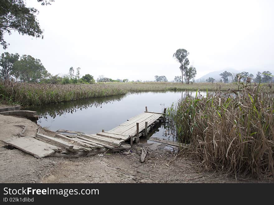 Landscape of waterfront with crude wooden bridge. Landscape of waterfront with crude wooden bridge.