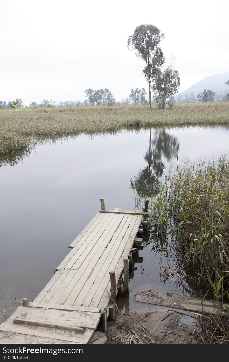 Landscape of waterfront with crude wooden bridge. Landscape of waterfront with crude wooden bridge.