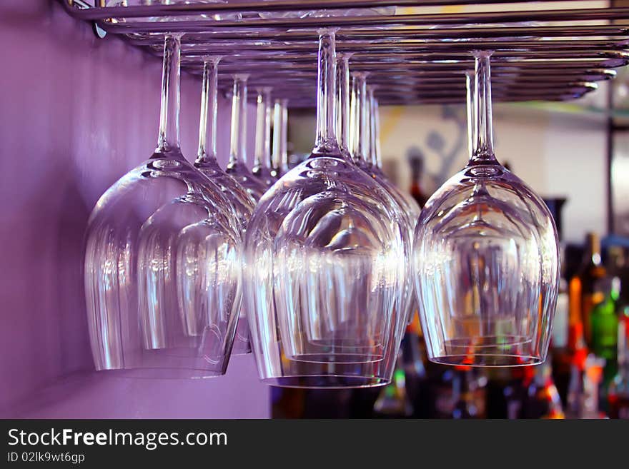 Photo of wine glasses in bar and purple wall