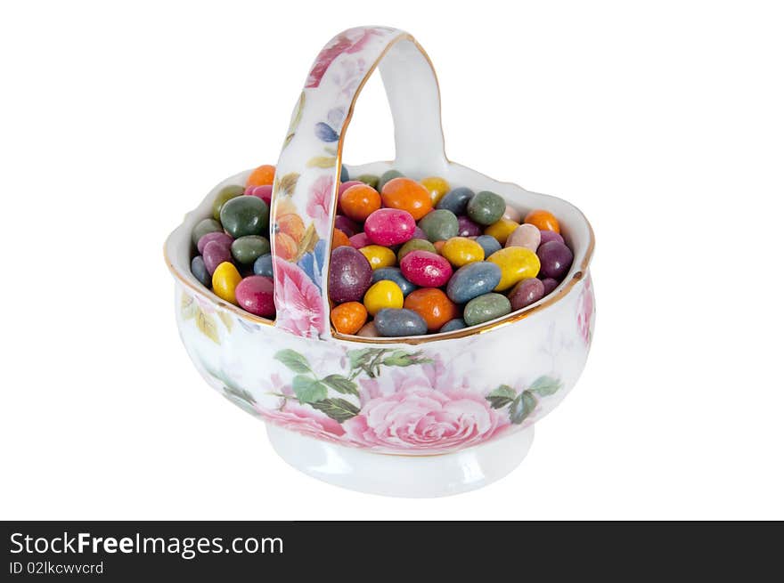 Multi-colored candies in a porcelain vase isolation