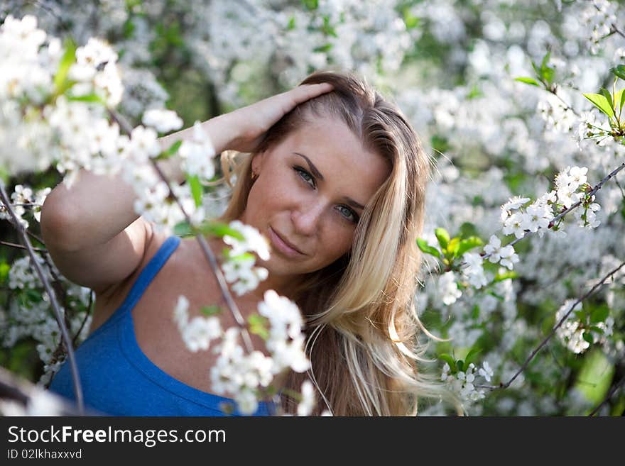 Blonde model in the cherry garden on spring. Blonde model in the cherry garden on spring