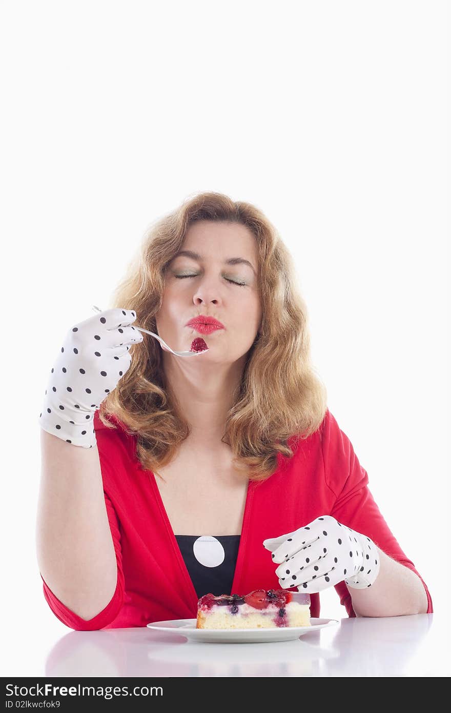 Middle-aged woman in red with gloves eating cake. Middle-aged woman in red with gloves eating cake