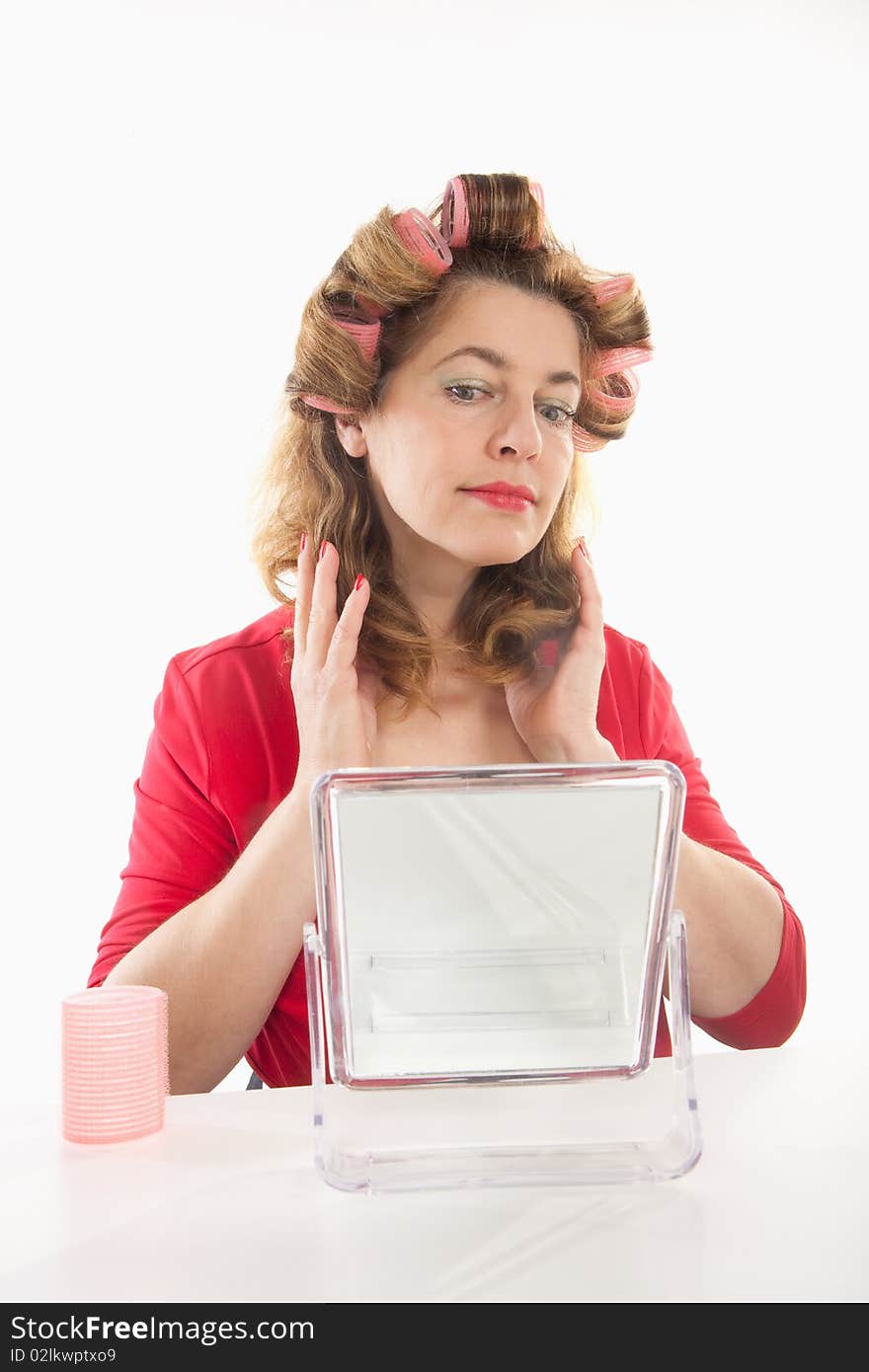 Middle-aged woman in red with hair rollers - isolated on white. Middle-aged woman in red with hair rollers - isolated on white