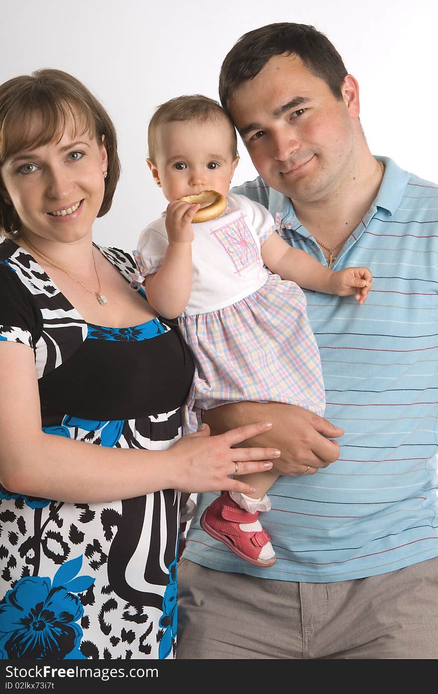 Happy family portrait of a baby with her parents over a white background