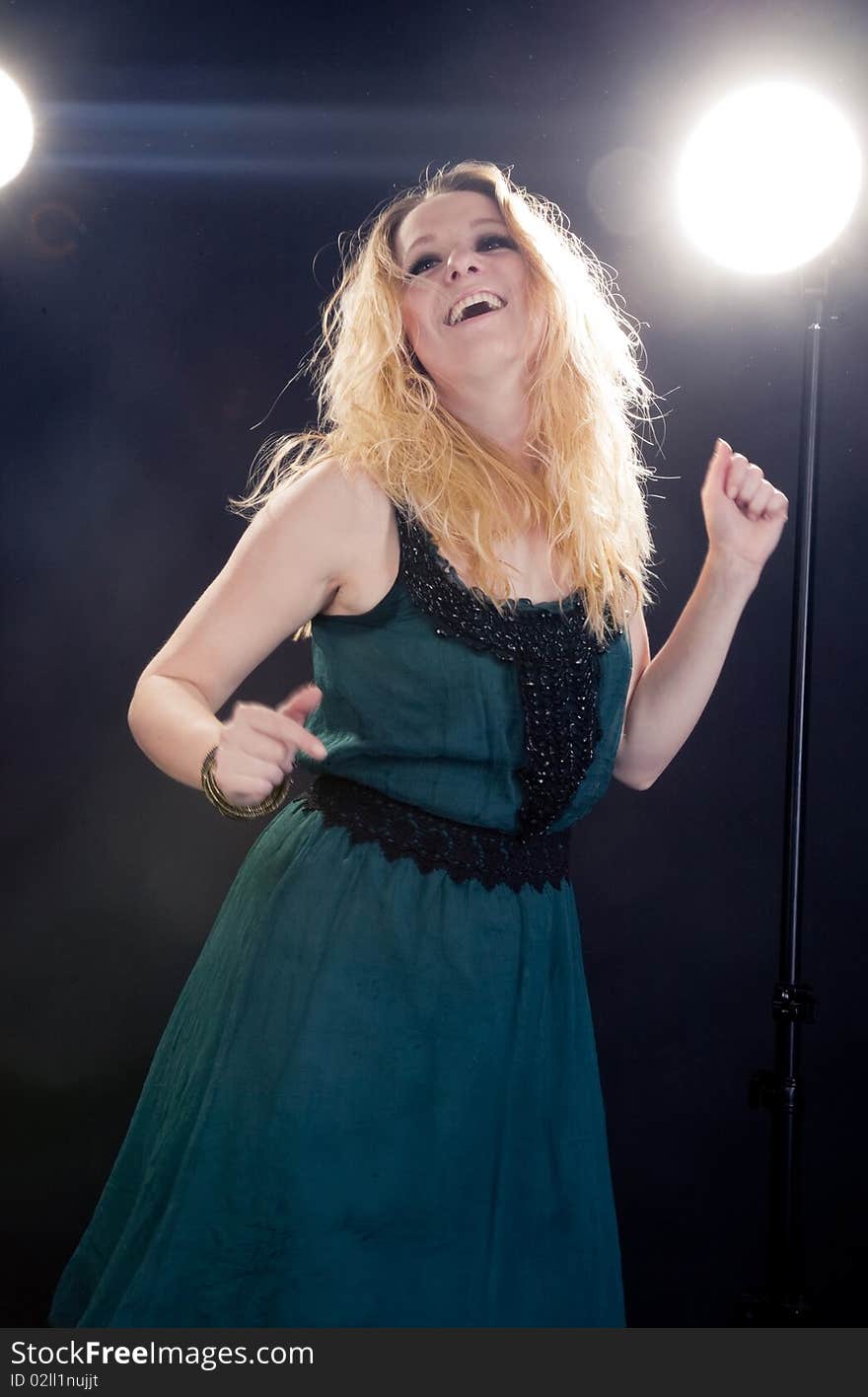 Young woman in a dark room in the glow of floodlights in motion. Young woman in a dark room in the glow of floodlights in motion