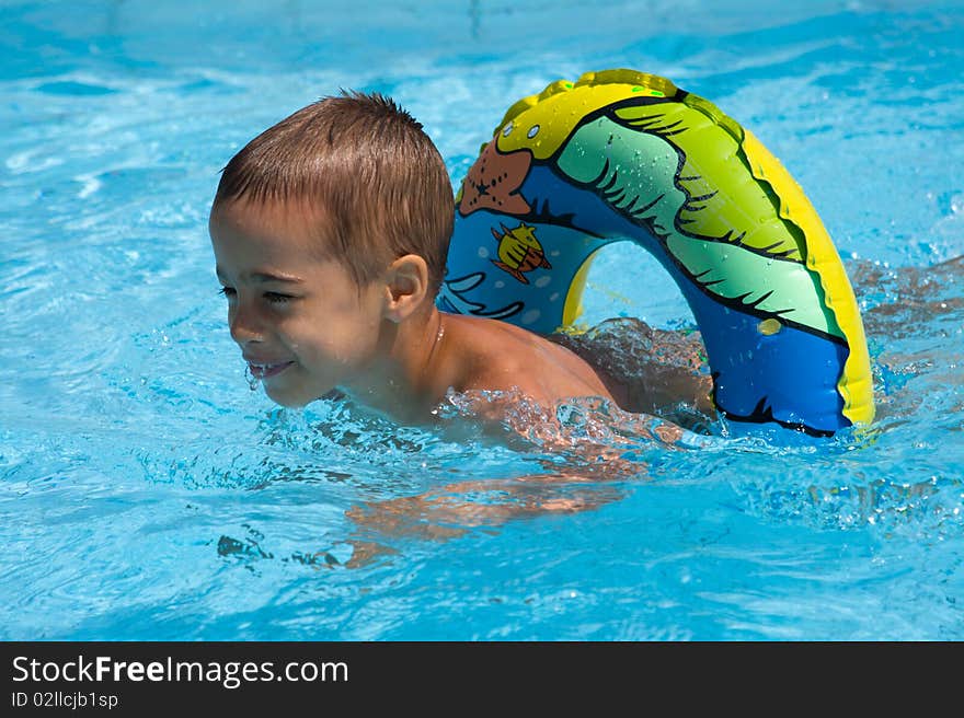 Little boy swimming in swimming pool with life belt. Little boy swimming in swimming pool with life belt