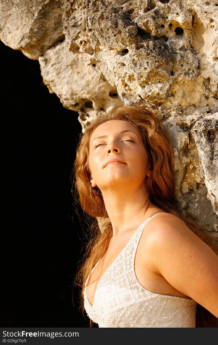 Portrait of the girl standing at a stone wall