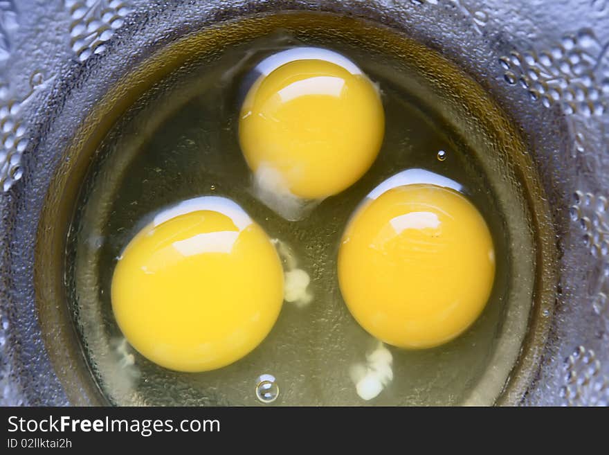 Three egg yolk on glass bowl. Three egg yolk on glass bowl