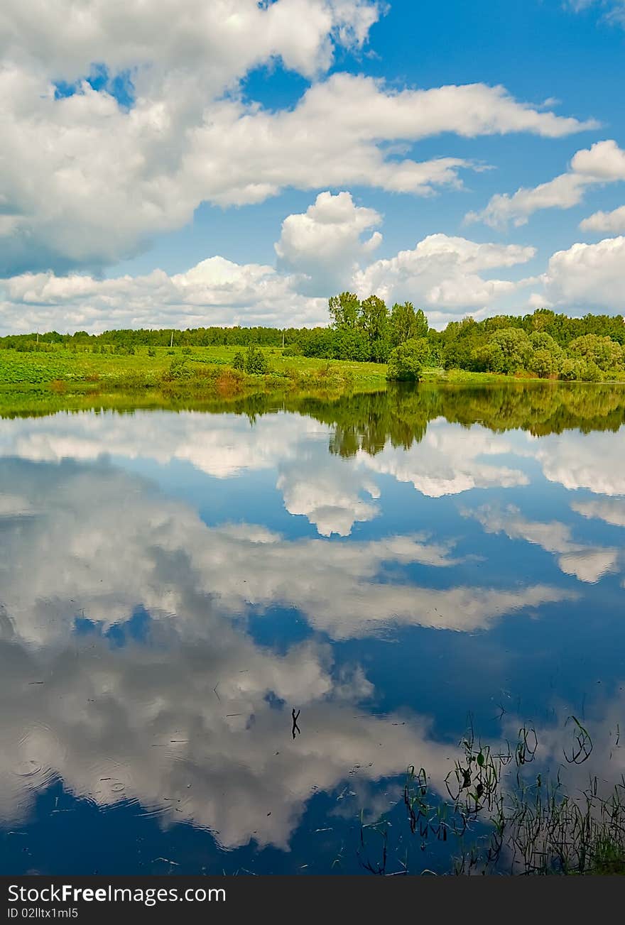 Cloud reflection in the rural russian river with forest on horizon. Cloud reflection in the rural russian river with forest on horizon