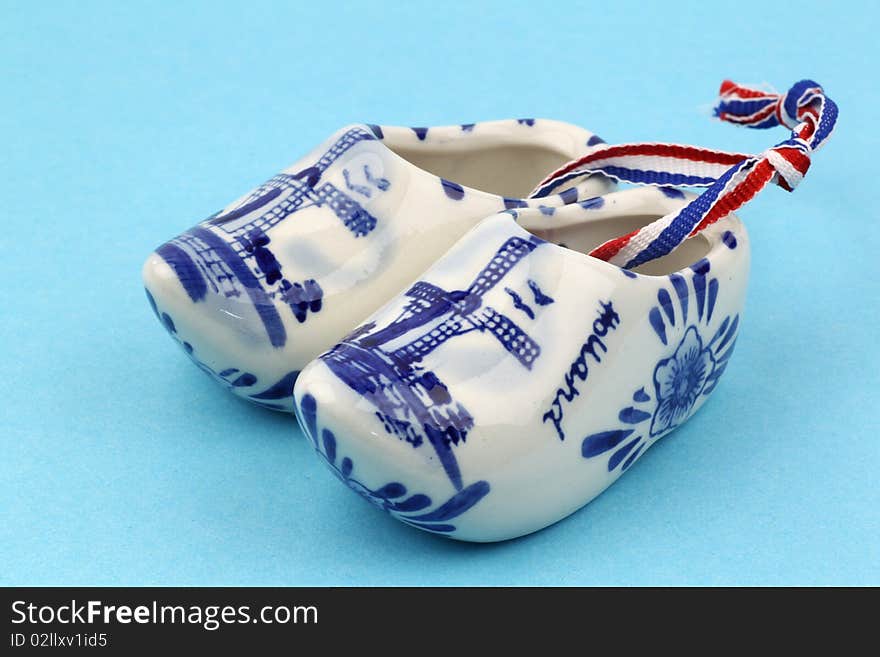 Delft blue ceramic wooden shoes from Holland on a blue background