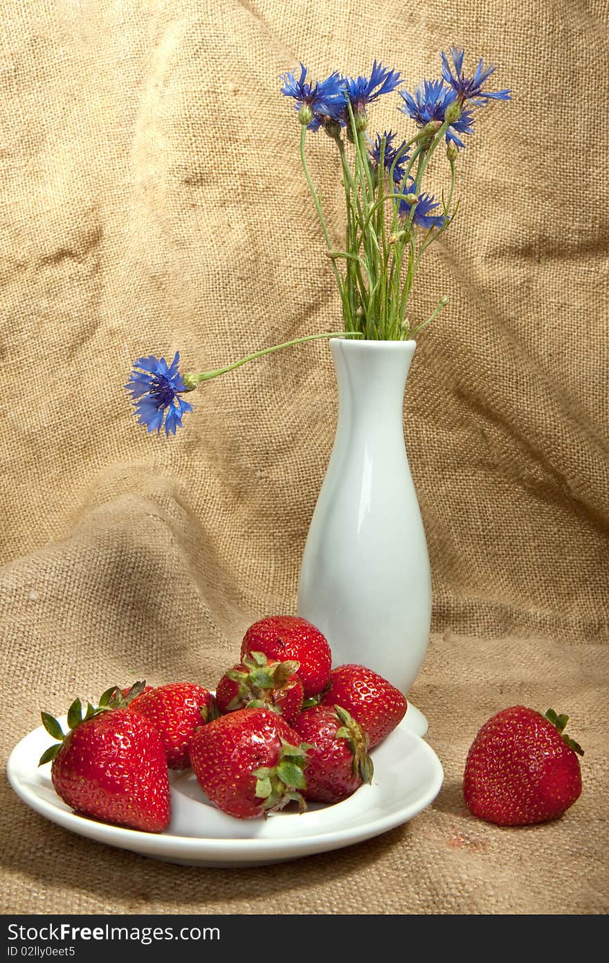 Fresh strawberry and vase with flowers