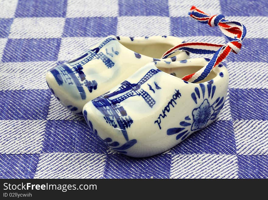 Delft blue ceramic wooden shoes from Holland on a blue checkered kitchen towel