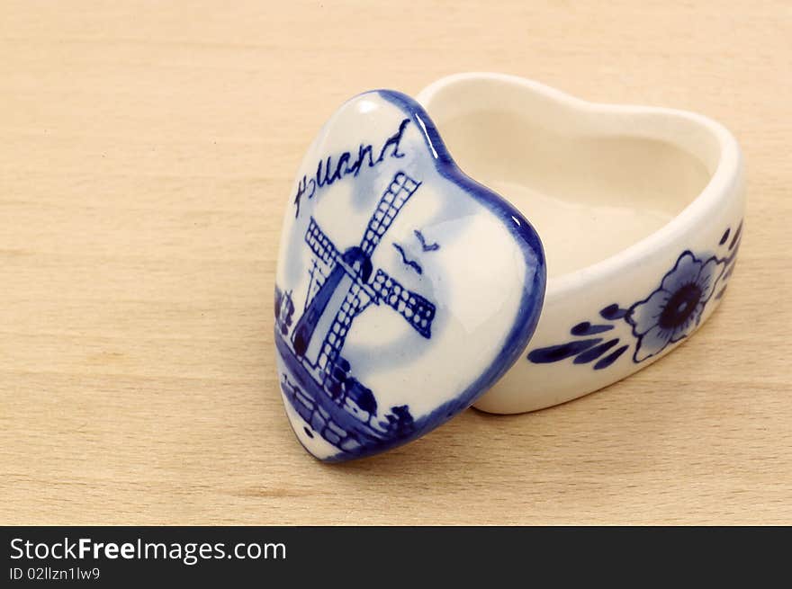 Opened ceramic pill box on a wooden background