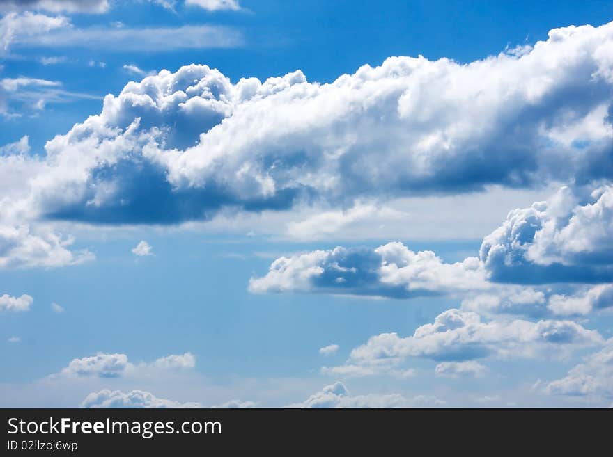 White cumulus clouds and a blue sky.