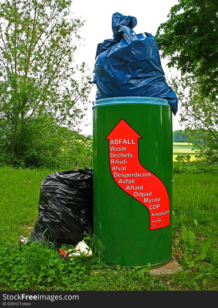 Overcrowded litter bin on a car park