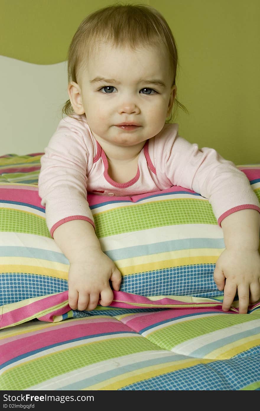 Baby girl laying on colorful bed