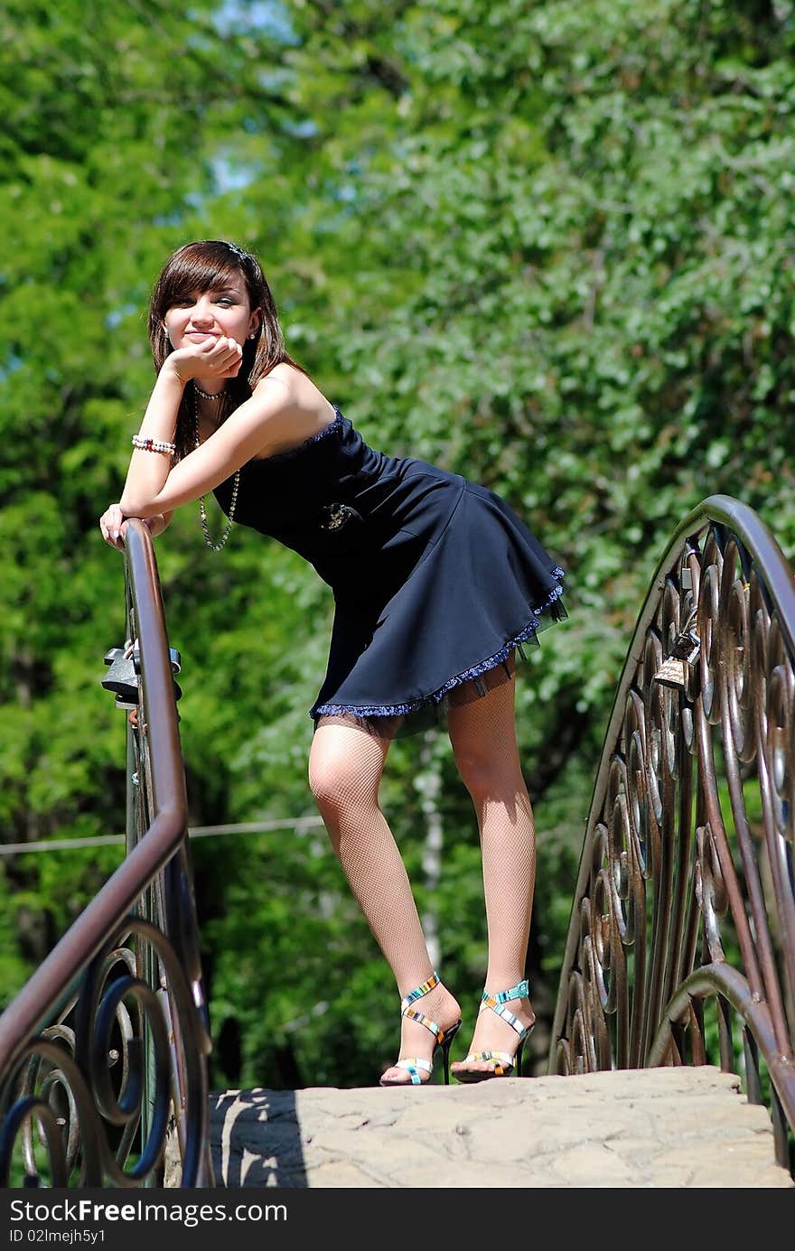 The young woman poses in the park in the summer