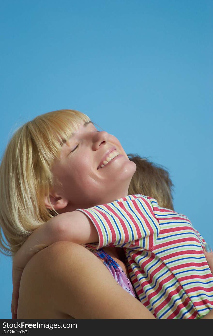 Mum with the small son on hands on a background of the dark blue sky. Mum with the small son on hands on a background of the dark blue sky