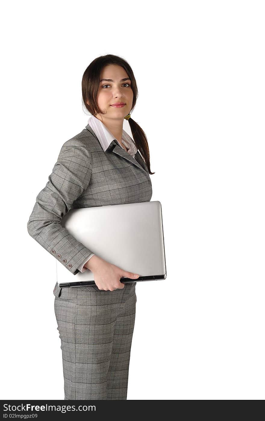 The young and beautiful business lady with the laptop under the arm looks in the camera on a white background. The young and beautiful business lady with the laptop under the arm looks in the camera on a white background