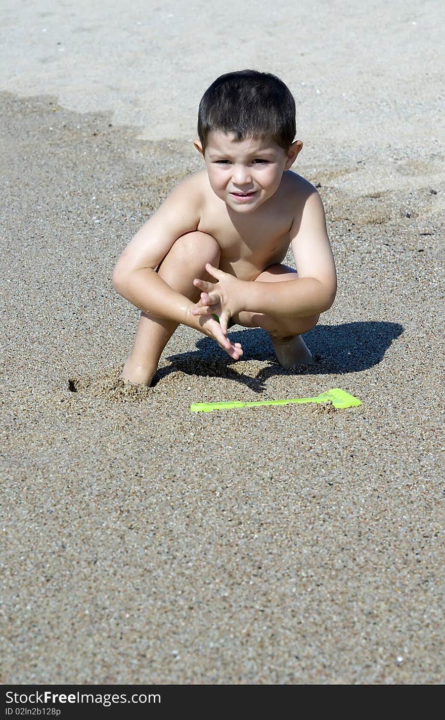 A kid playing on the beach sand. A kid playing on the beach sand