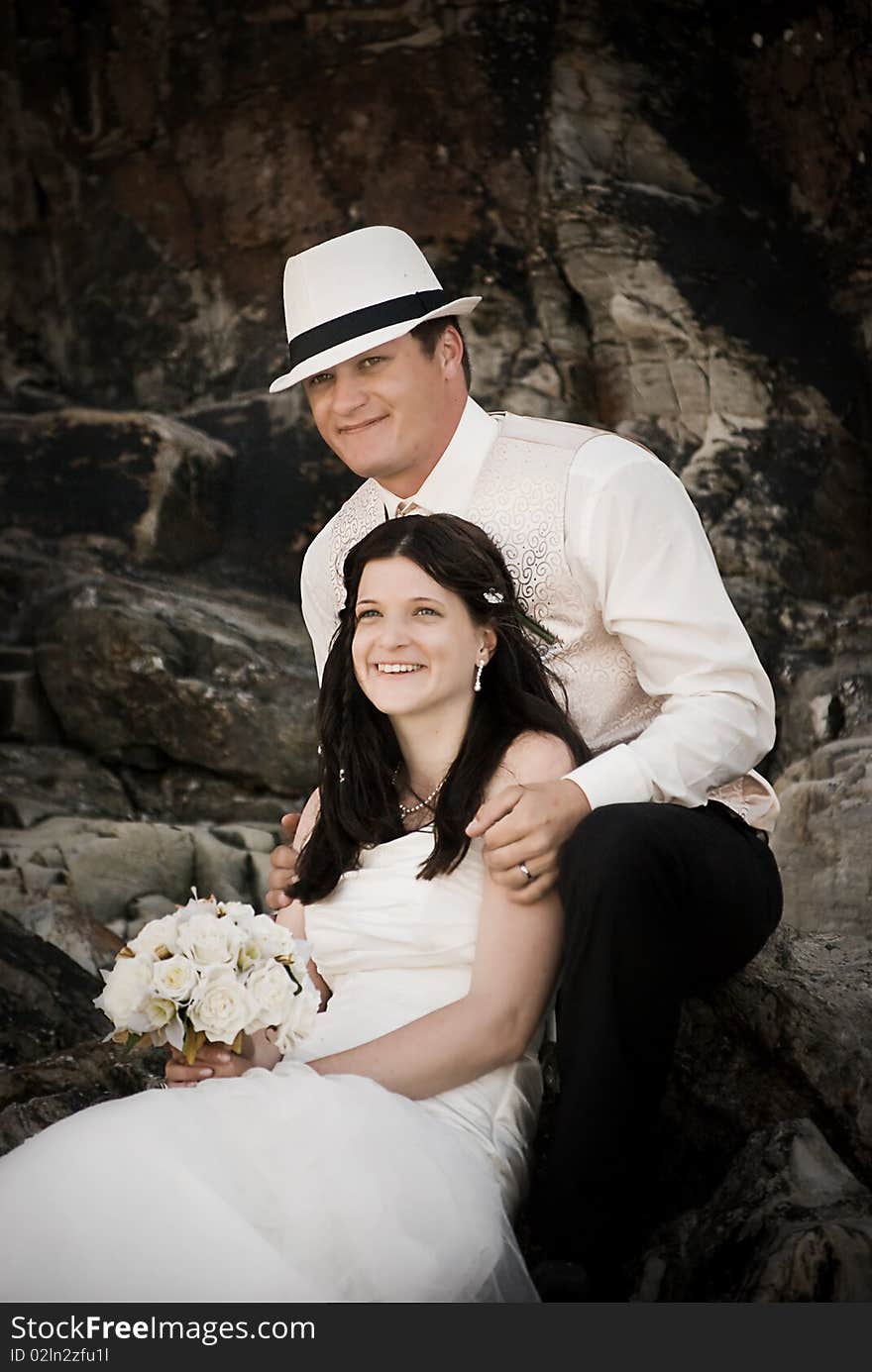 Bride and Groom sitting on the rocks shortly after being married.