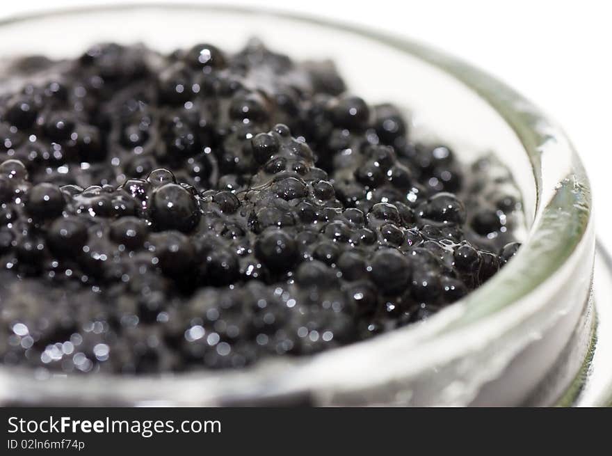 Black caviar in a glass jar on a white background