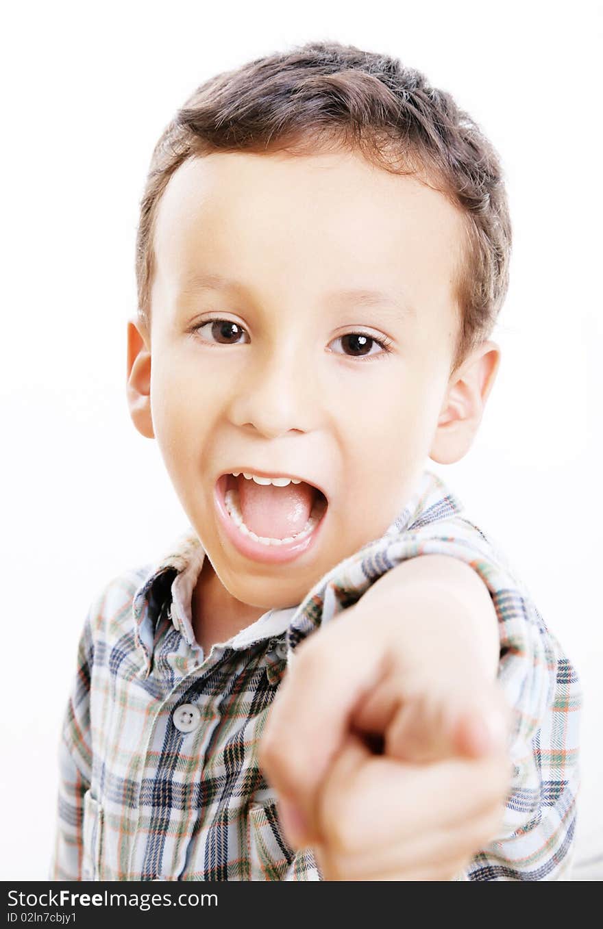 Child pointing and looking at the camera. White background. Child pointing and looking at the camera. White background