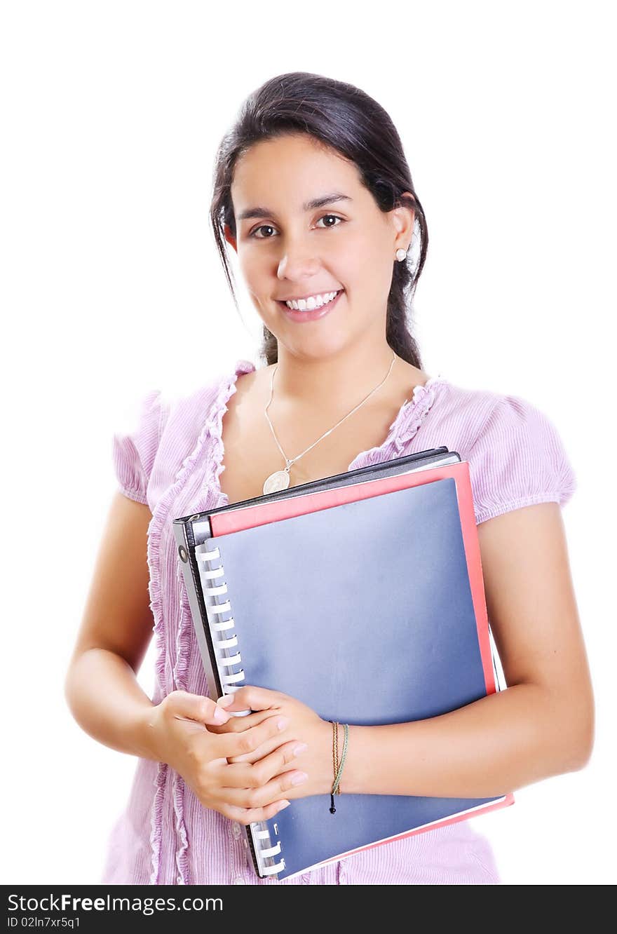 Young student with her books in hand, smiling and looking at the camera