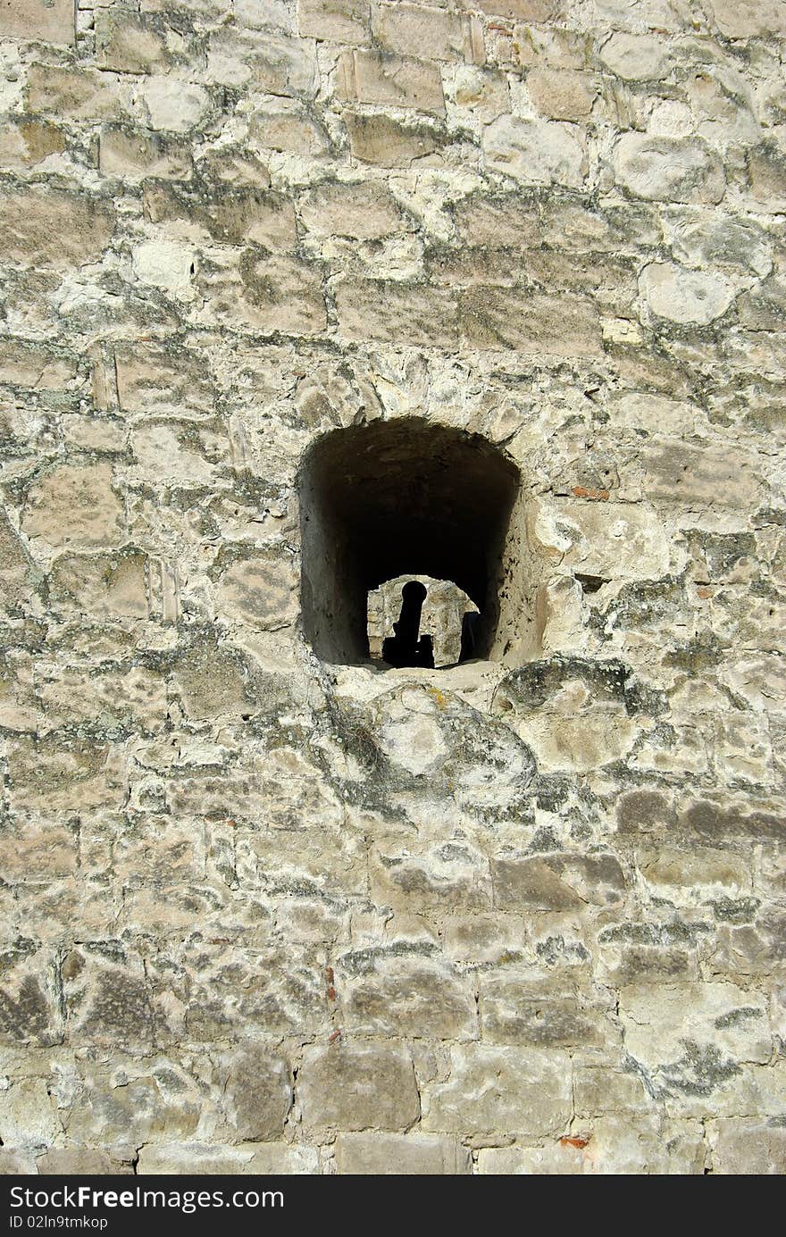 Stronghold stone wall with cannon in embrasure