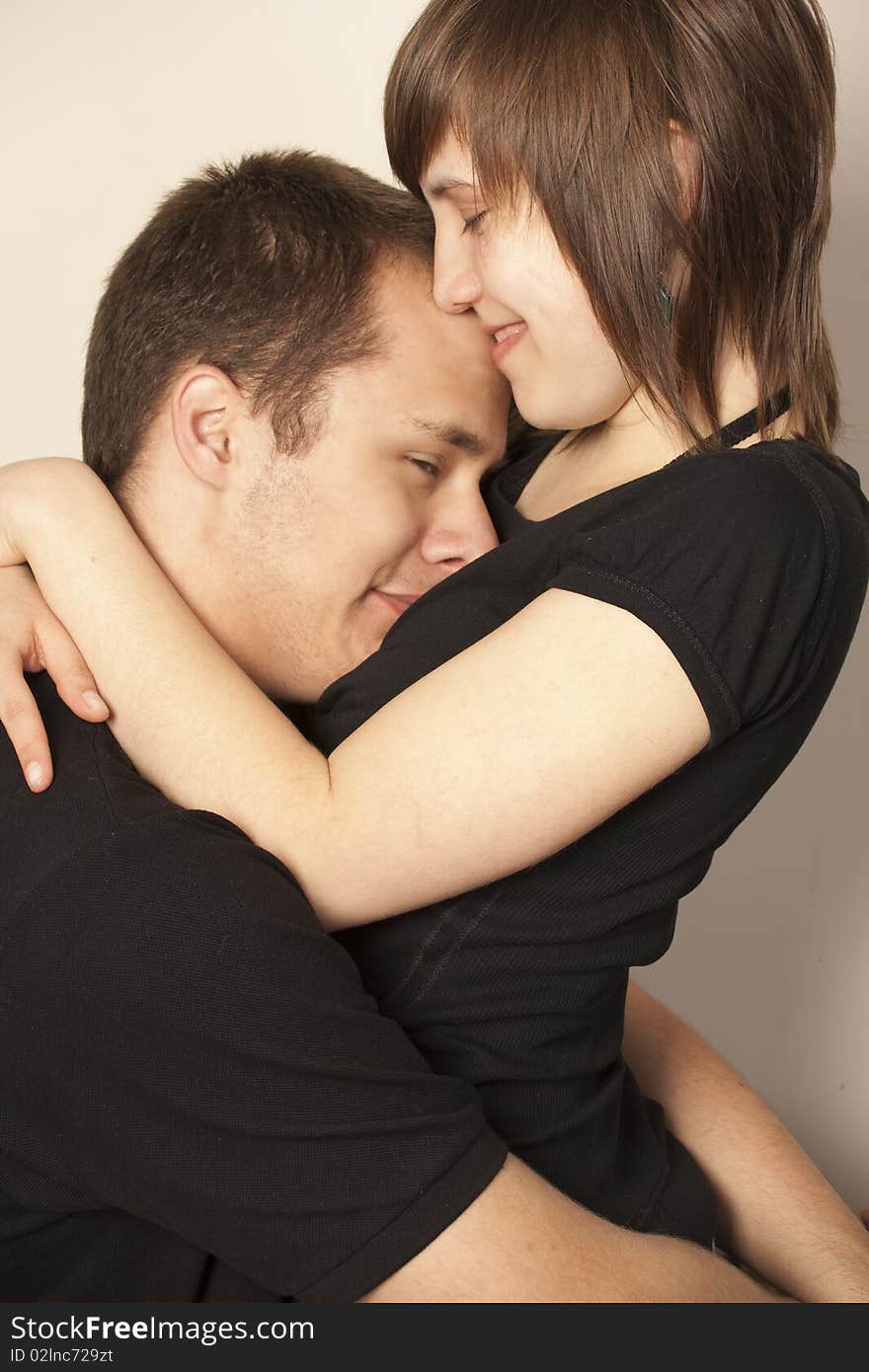 A pair of people standing and cuddling up. A pair of people standing and cuddling up.