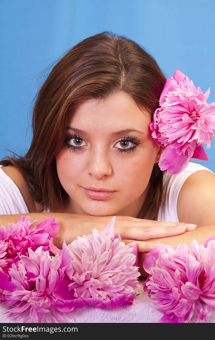 Beautiful woman surrounded by fresh picked summer peony flowers.