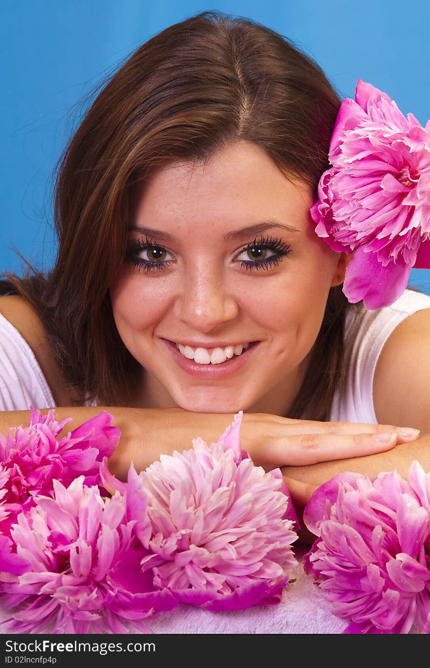 Beautiful woman surrounded by fresh picked summer peony flowers.