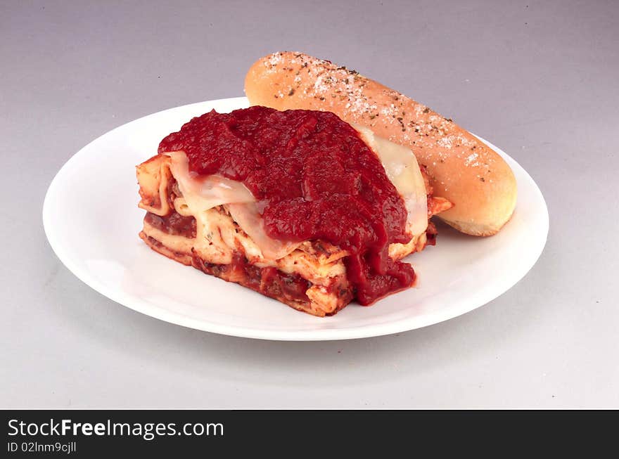 Meat lasagna with red sauce served with garlic bread. Meat lasagna with red sauce served with garlic bread