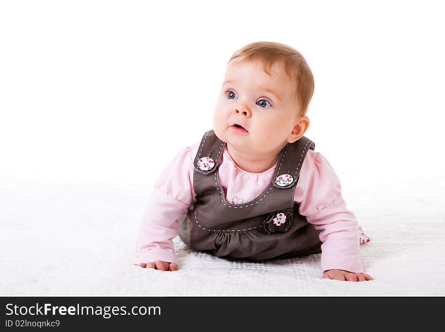 A baby girl is crawling along the floor with an inquisitive look on her face. Horizontal shot. A baby girl is crawling along the floor with an inquisitive look on her face. Horizontal shot.