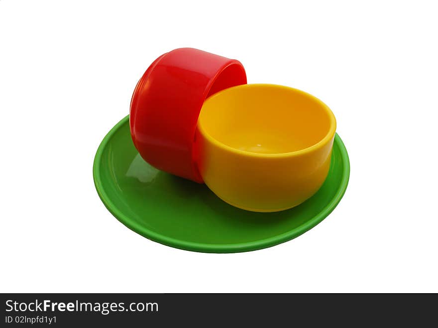 Red and yellow mugs on a green plate. Red and yellow mugs on a green plate