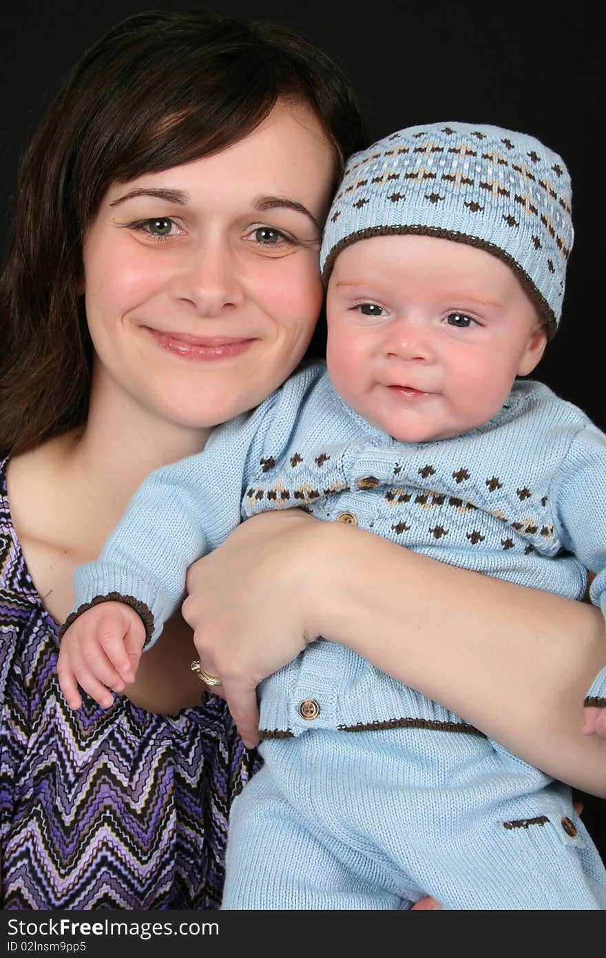 Beautiful brunette mother with her baby boy dressed in blue. Beautiful brunette mother with her baby boy dressed in blue