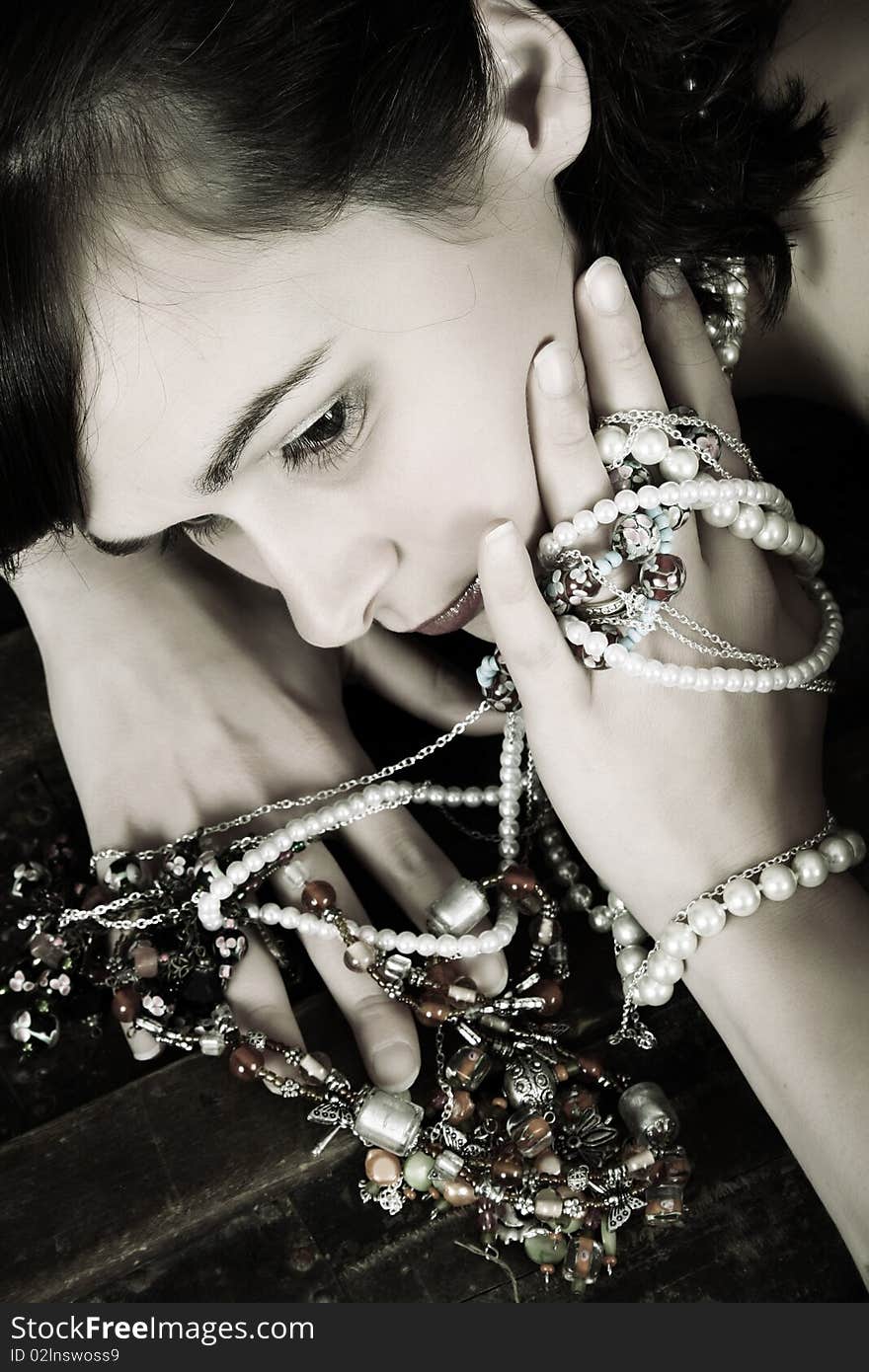 Beautiful brunette against a rugged antique chest with jewellery. Beautiful brunette against a rugged antique chest with jewellery