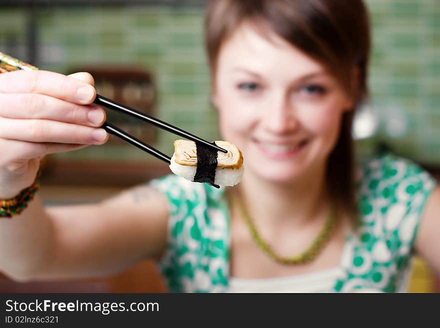 An image of a nice woman eating sushi. An image of a nice woman eating sushi