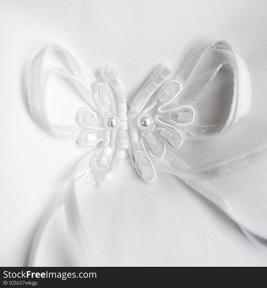 Beautiful detail of a white wedding rings pillow. Beautiful detail of a white wedding rings pillow