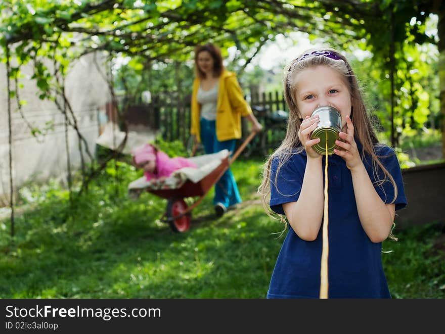 An image of a girl with a toy-telephone. An image of a girl with a toy-telephone