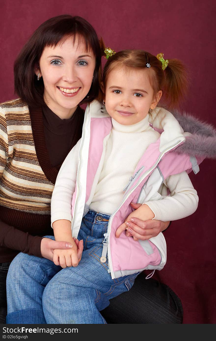 Happy mother with little daughter on red background