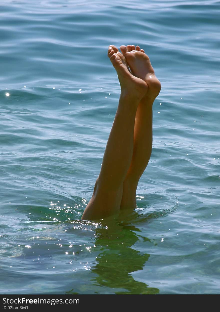 Young women feet in the blue Adriatic sea