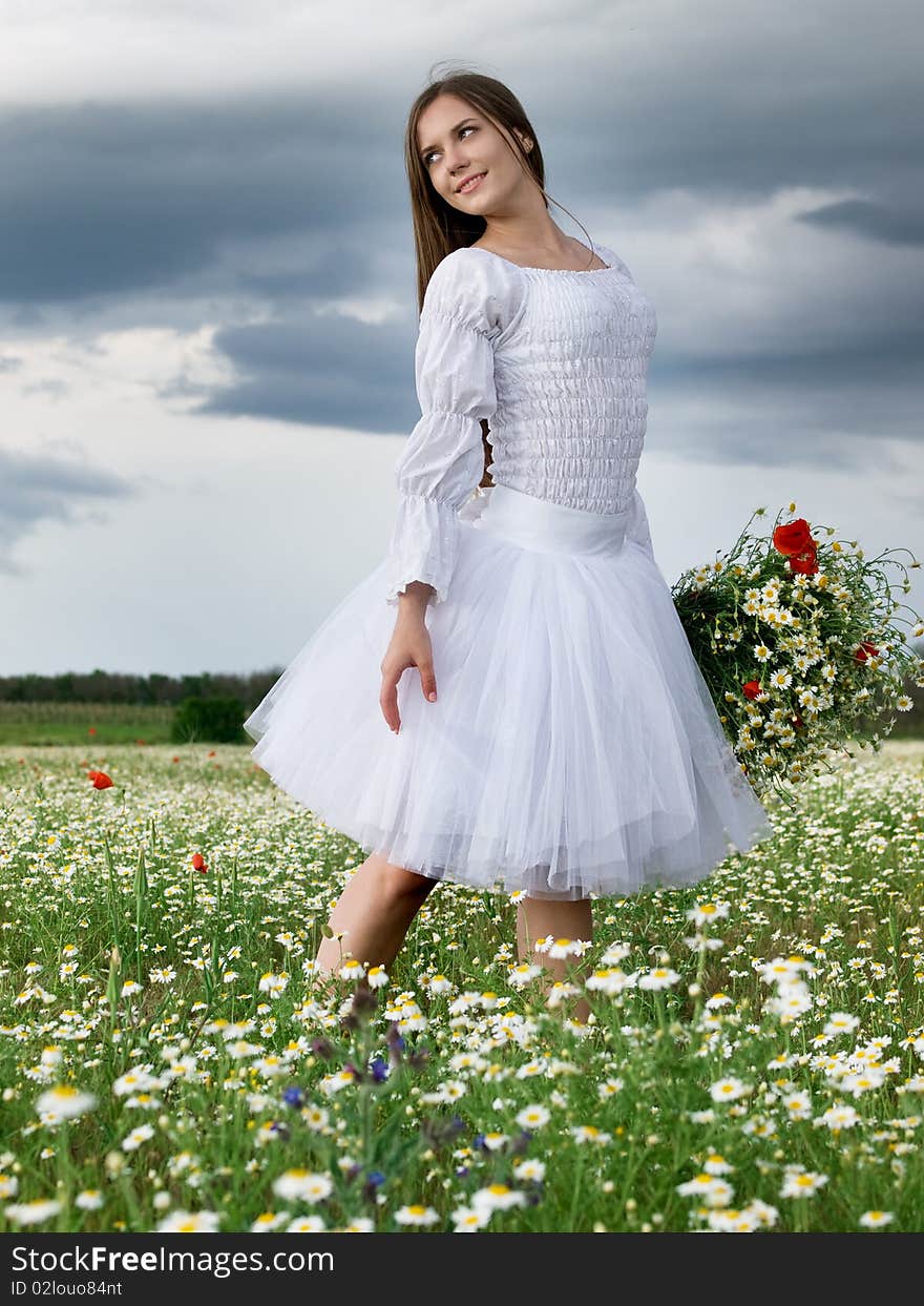 Young happy girl with bouquet in daisy field. Young happy girl with bouquet in daisy field